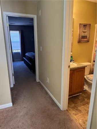 a view of a hallway and a livingroom with furniture