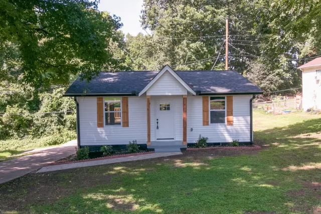 a front view of a house with a garden and yard