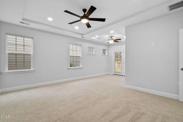 an empty room with ceiling fan and window