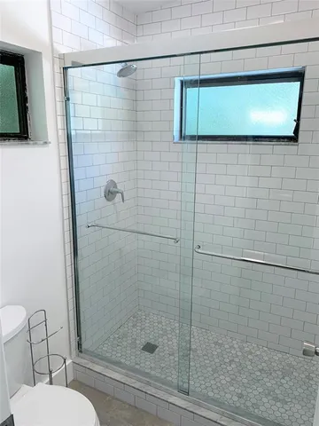a bathroom with a toilet and a shower