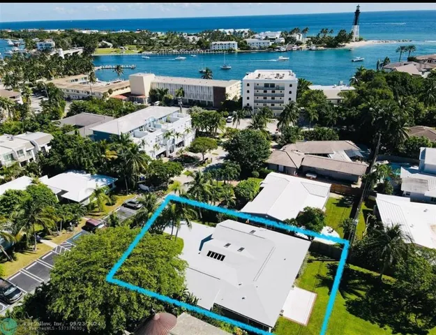 an aerial view of a house with a garden and lake view