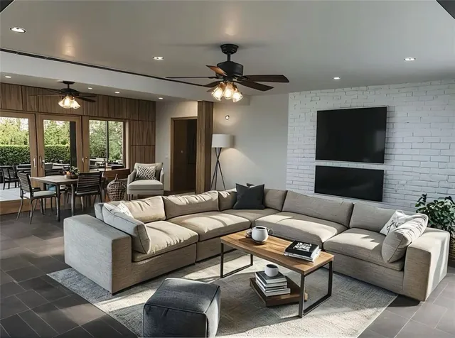 a living room with furniture ceiling fan and a flat screen tv