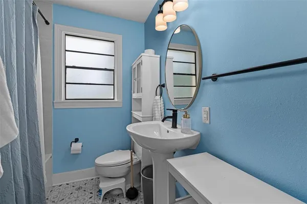 a bathroom with a toilet a sink and mirror