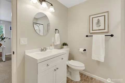 a bathroom with a toilet a sink a mirror and a shower