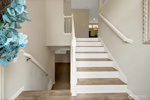 a view of staircase with white walls and wooden floor