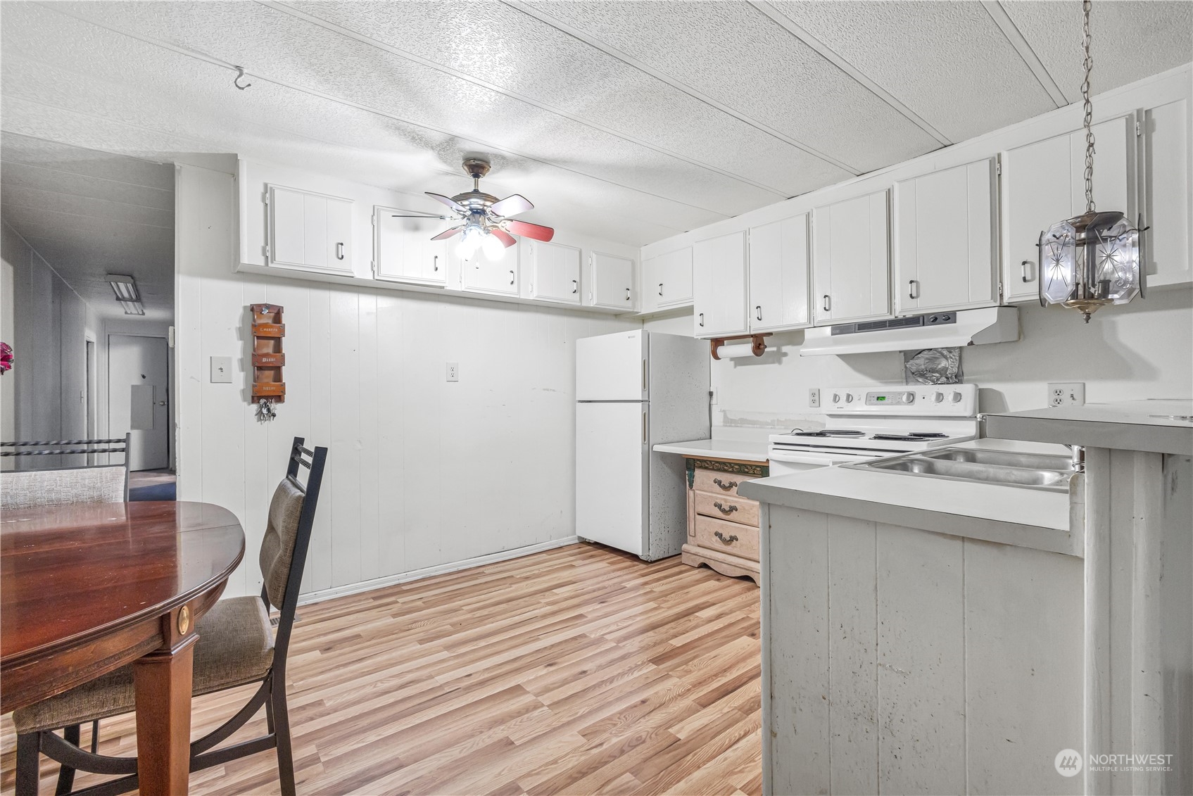 1729 Southeast 194th Street, Unit 32 Bothell, WA 98012 - Photo 8 of 19 a kitchen with stainless steel appliances granite countertop a sink dishwasher a stove a dining table and chairs with wooden floor