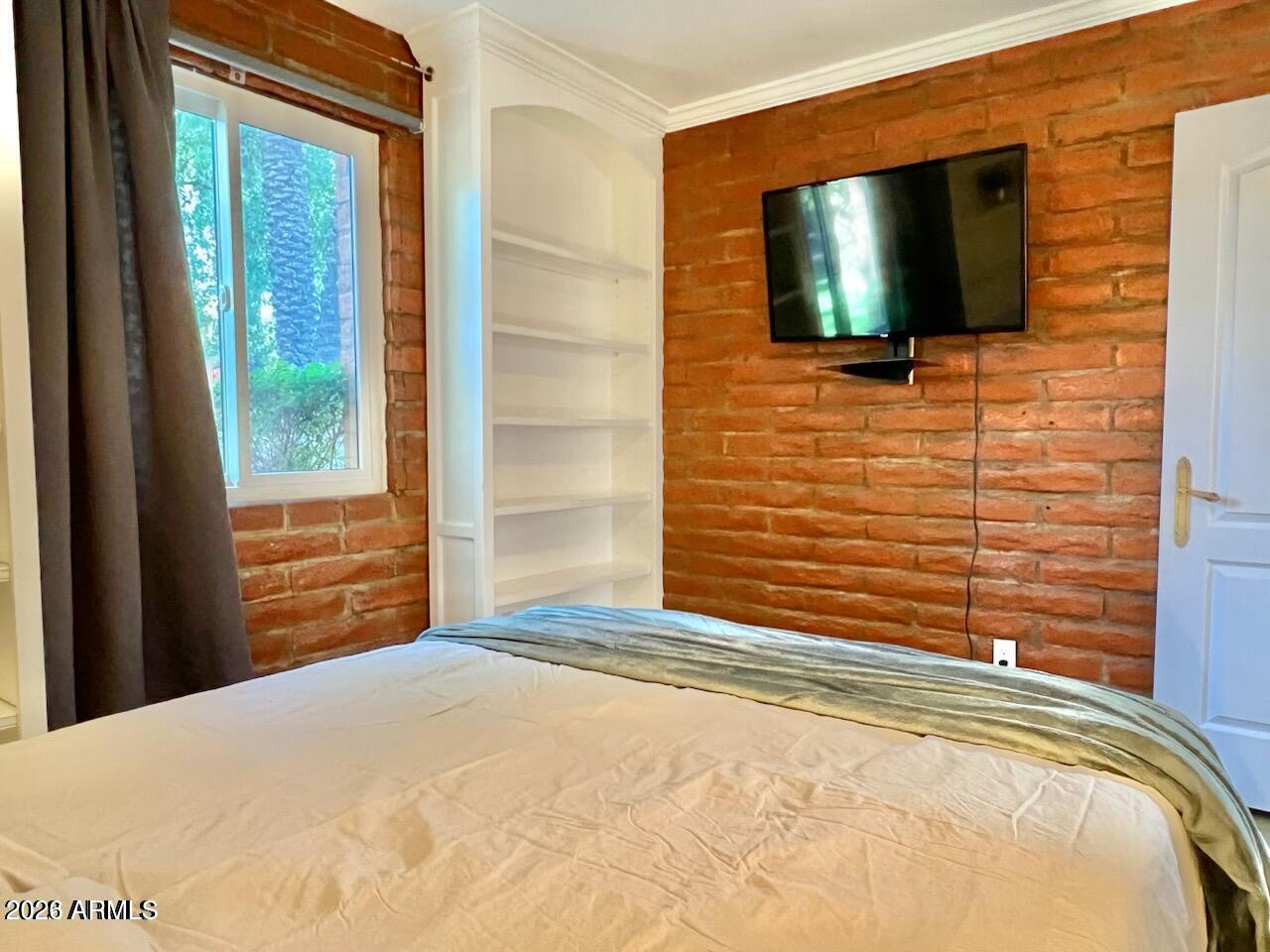 3022 North 32nd Street, Unit 51 Phoenix, AZ 85018 - Photo 14 of 19 a bedroom with a bed and a flat screen tv