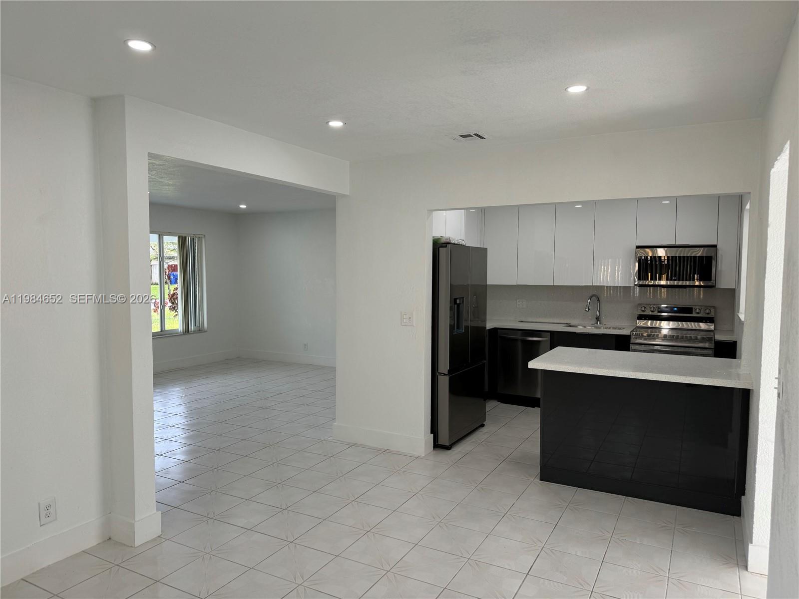 2400 North 57th Way Hollywood, FL 33021 - Photo 4 of 9 a kitchen with stainless steel appliances granite countertop a refrigerator and a stove top oven