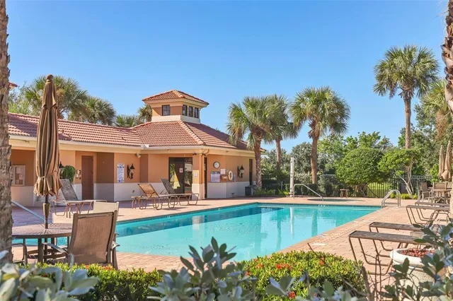 a view of a building with a swimming pool and a chairs