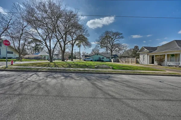 a view of a house with a big yard and large trees