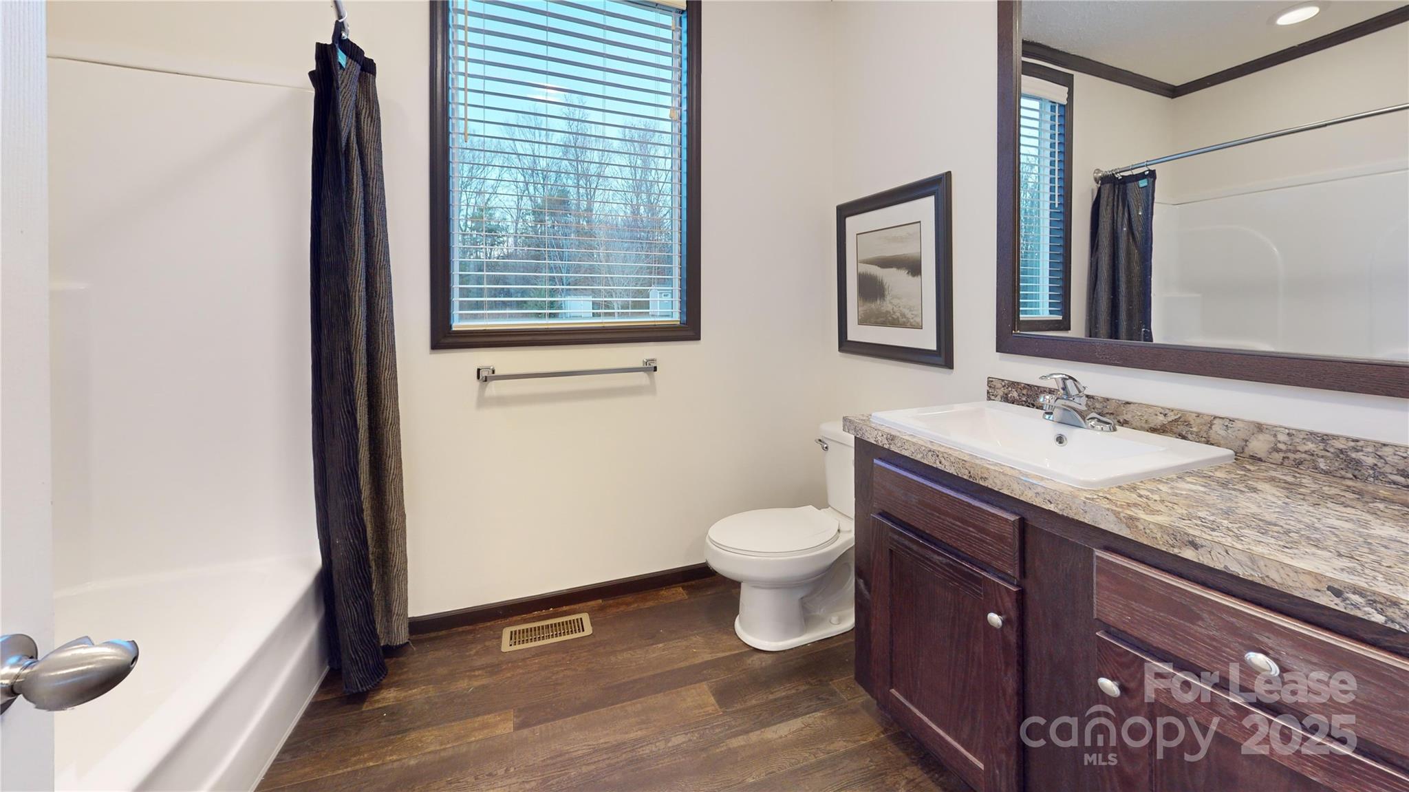 7708 Waxhaw Highway Waxhaw, NC 28173 - Photo 20 of 28 a bathroom with a granite countertop sink toilet and mirror