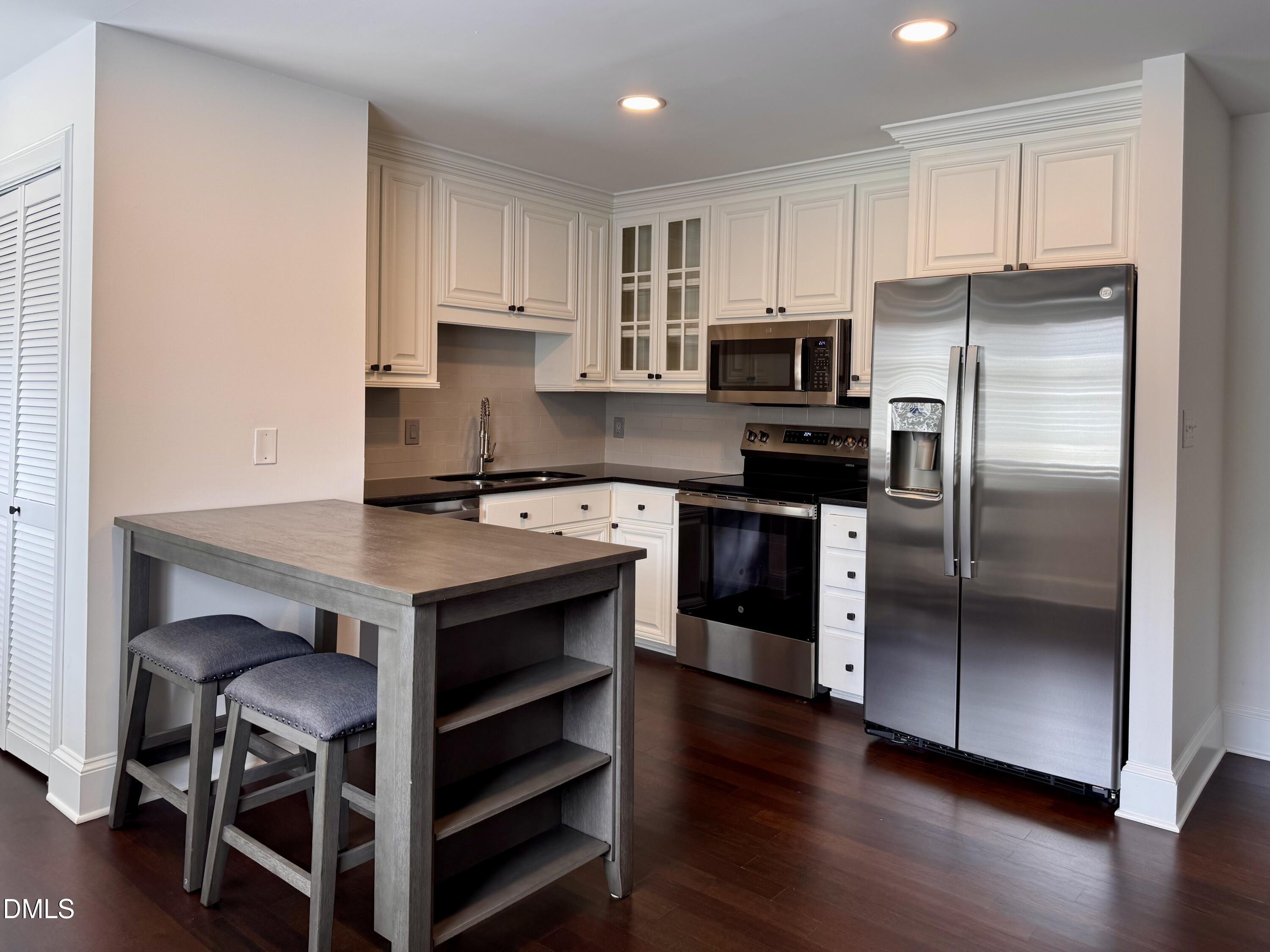 2204 Stafford Avenue, Unit 202 Raleigh, NC 27607 - Photo 3 of 15 a kitchen with kitchen island a counter space stainless steel appliances and cabinets