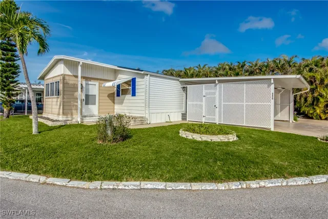 a view of a house with a yard potted plants and large tree