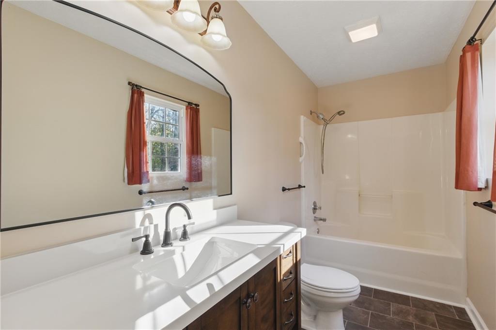218 Eden Woods Clarkesville, GA 30523 - Photo 11 of 35 a bathroom with a granite countertop sink a toilet and shower