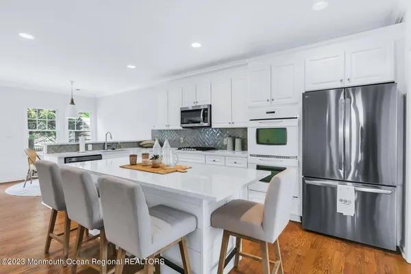 a kitchen with white cabinets and appliances