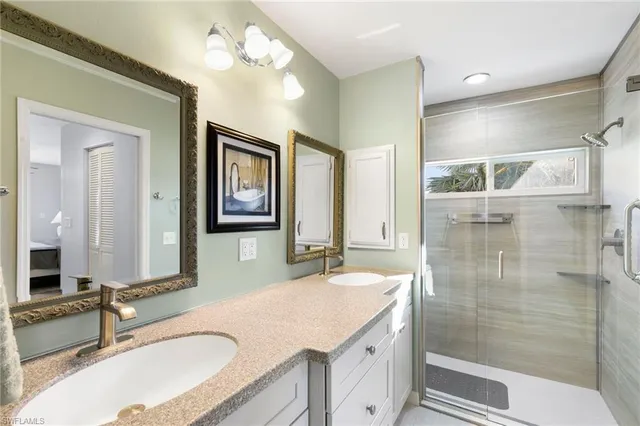 a bathroom with a granite countertop double vanity sink and a mirror
