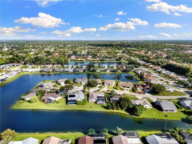 an aerial view of a houses with a lake