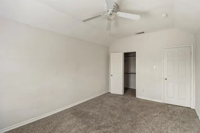 an empty room with a ceiling fan and a window
