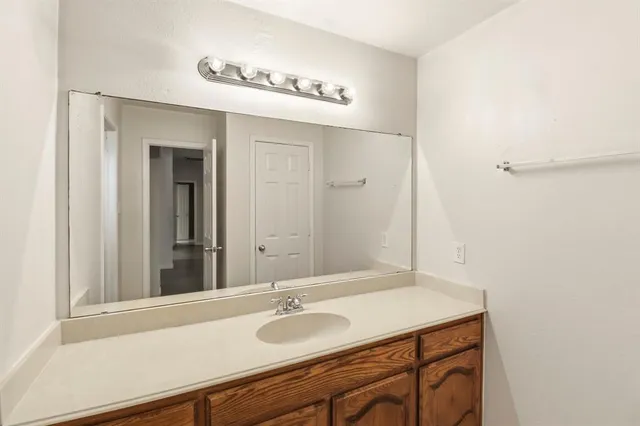a bathroom with a granite countertop sink and a mirror