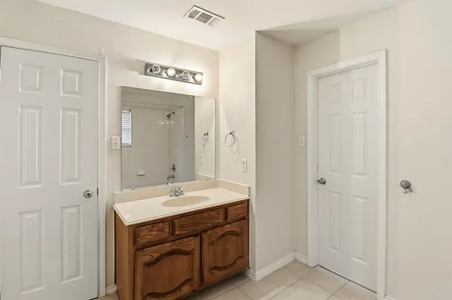 a spacious bathroom with a sink and a mirror