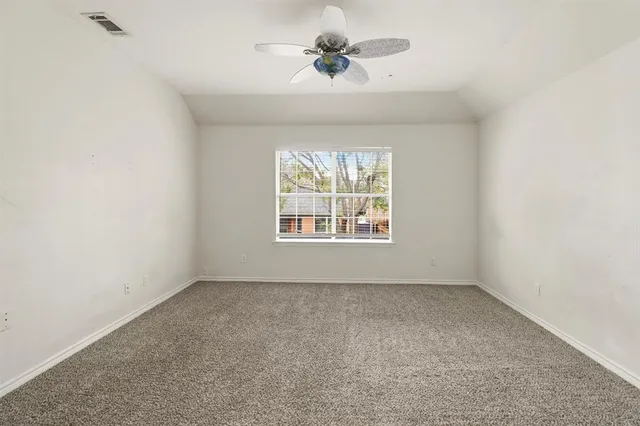 an empty room with a window and a ceiling fan