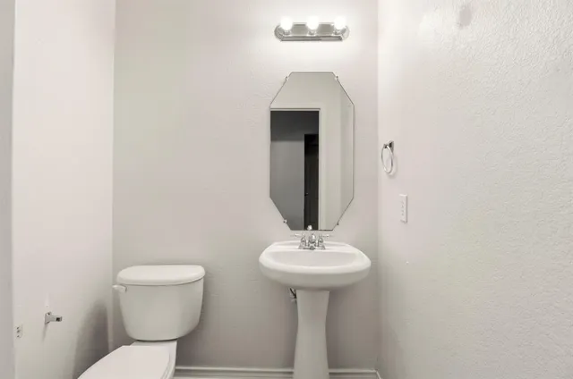 a bathroom with a toilet sink and mirror