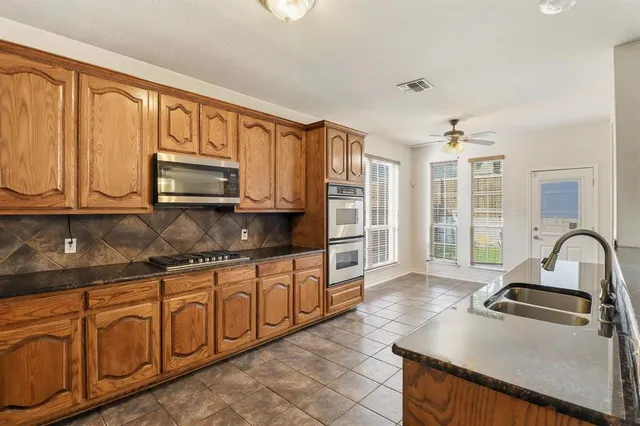 a kitchen with stainless steel appliances granite countertop a stove sink and cabinets