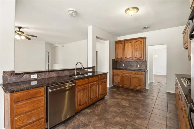 a kitchen with stainless steel appliances granite countertop a sink and cabinets