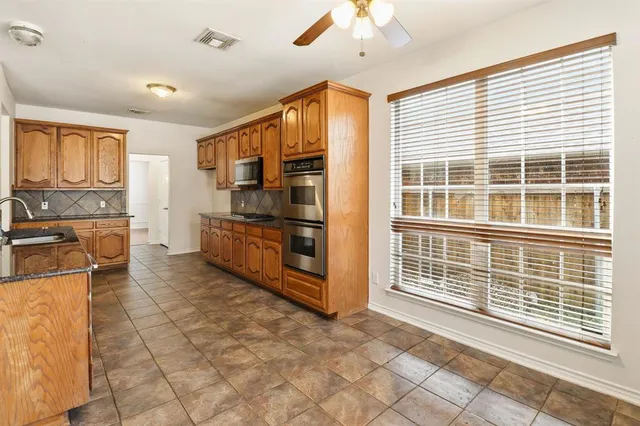 a view of a kitchen with stainless steel appliances windows in it