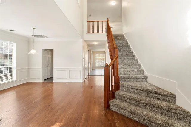 a view of a hallway with wooden floor and staircase