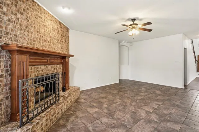 a view of a livingroom with a chandelier fan and a fireplace