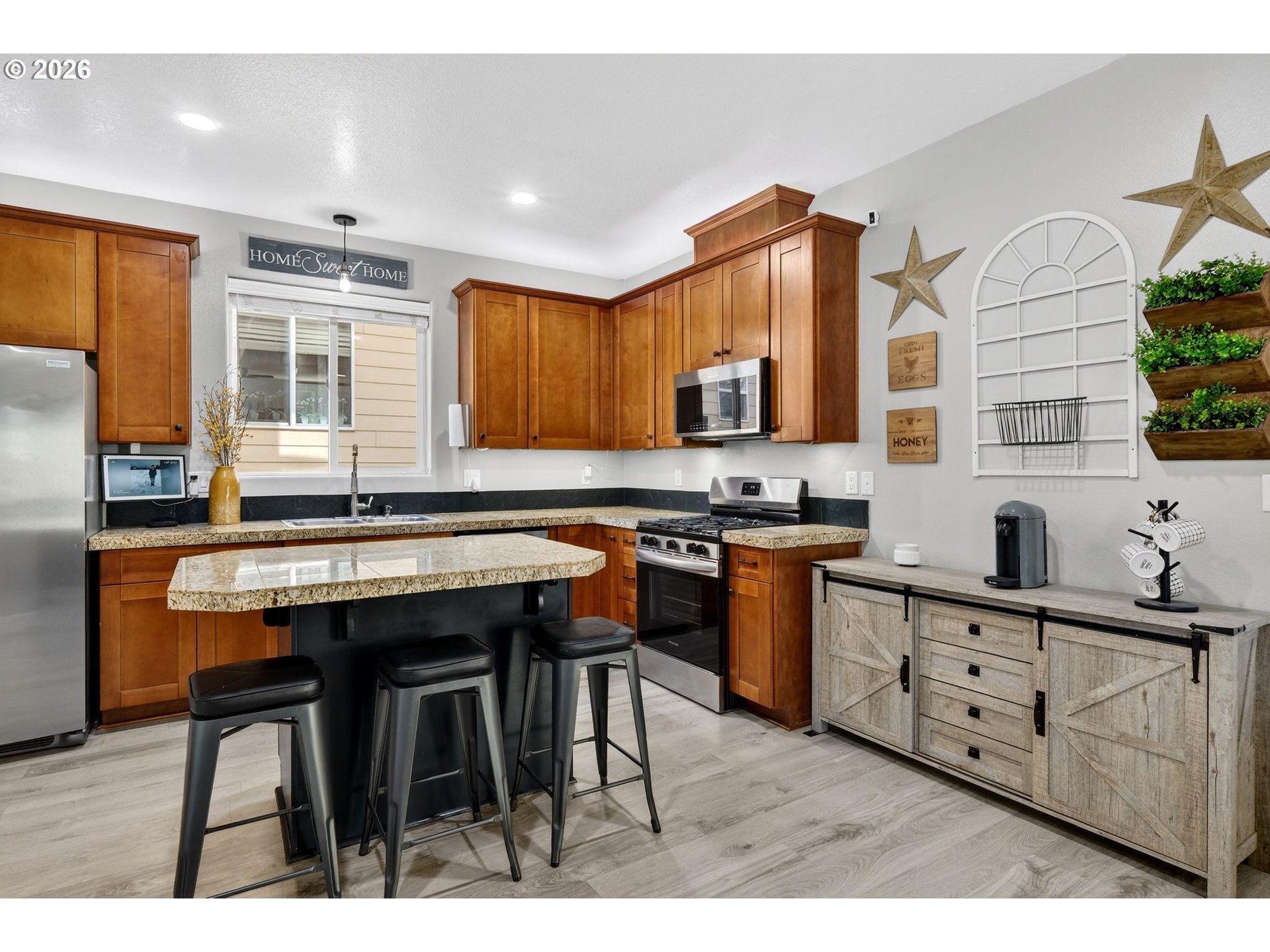19135 Southeast Village Boulevard Sandy, OR 97055 - Photo 14 of 43 a kitchen with stainless steel appliances granite countertop a stove a sink dishwasher and cabinets with wooden floor