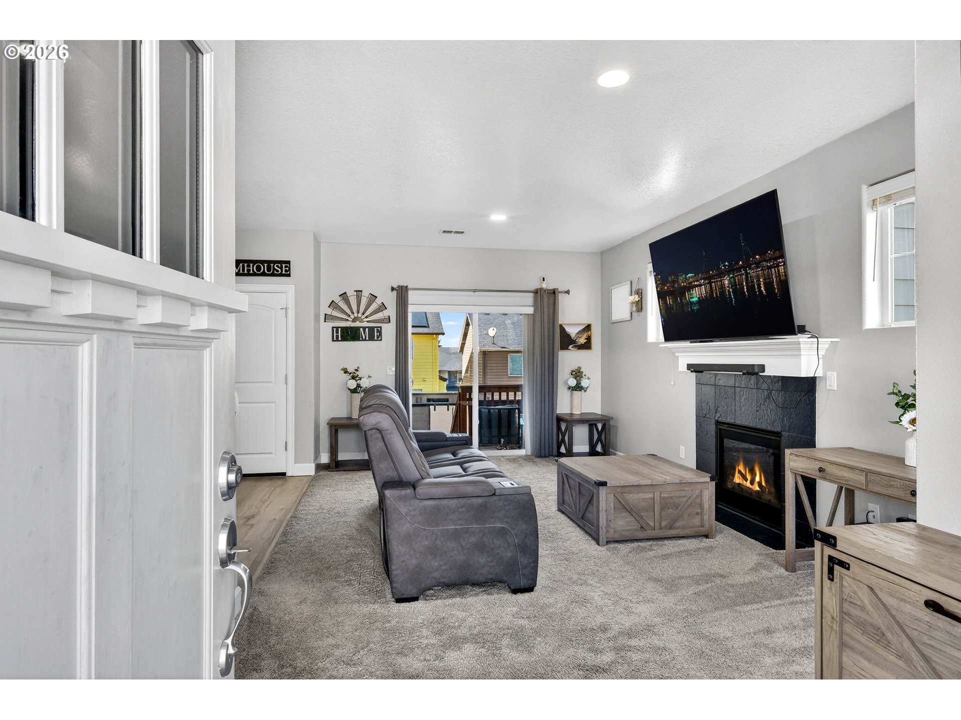 19135 Southeast Village Boulevard Sandy, OR 97055 - Photo 7 of 43 a living room with furniture a fireplace and a flat screen tv