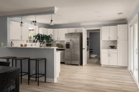 a kitchen with granite countertop a refrigerator and a stove top oven