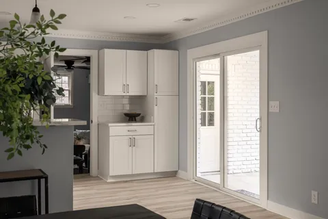 a kitchen with white cabinets and a window