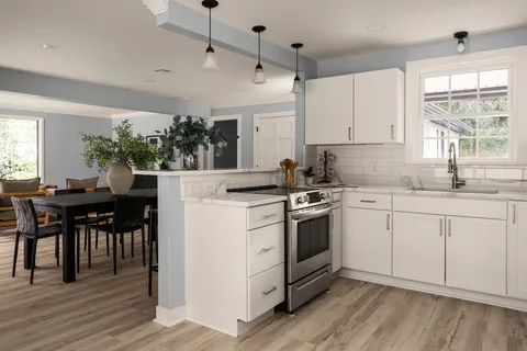 a kitchen with a stove a sink and white appliances