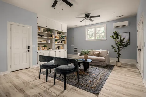a living room with furniture a rug and a window