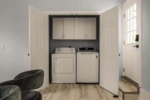 a utility room with wooden floor washer and dryer