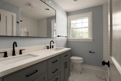 a bathroom with a sink a toilet and a window