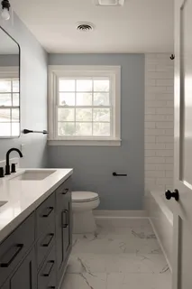 a bathroom with a granite countertop sink a toilet and shower