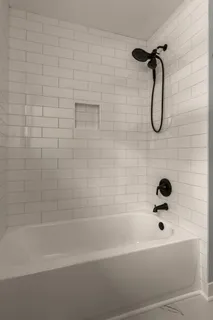 a bathroom with a bath tub with a shower