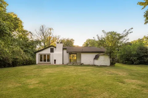 a house view with swimming pool in front of it