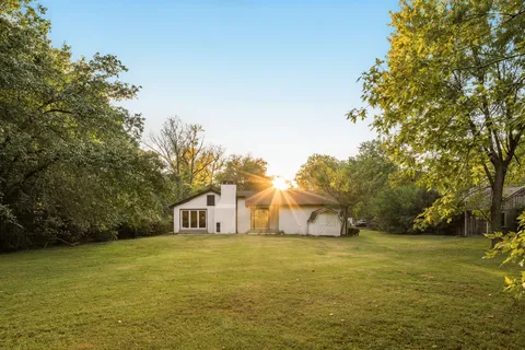 a house view with swimming pool in front of it