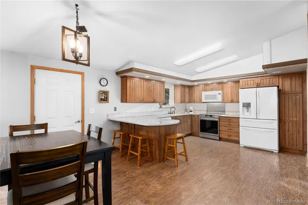 a dining room with a table chairs and kitchen view