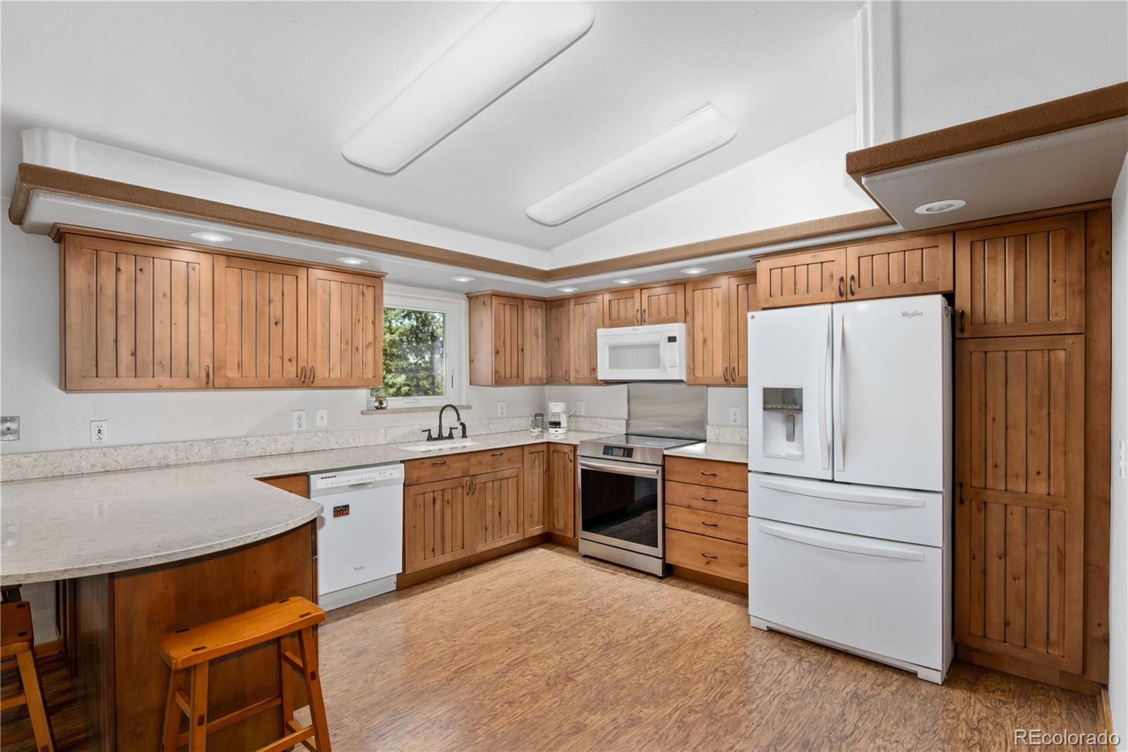 20065 Spring Creek Road Buffalo Creek, CO 80425 - Photo 12 of 41 a kitchen with stainless steel appliances granite countertop a refrigerator a sink dishwasher a stove and white countertops with wooden floor