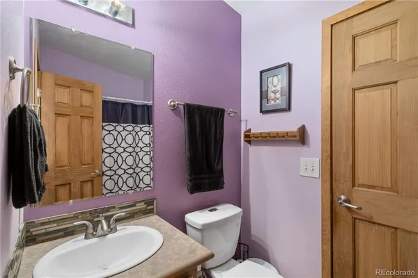 a bathroom with a granite countertop toilet sink and mirror
