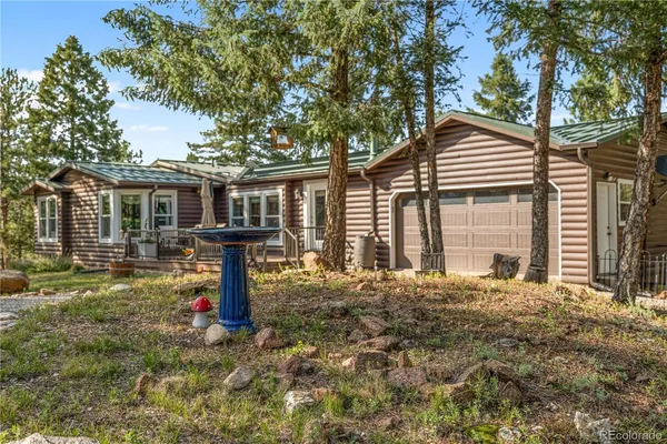 a front view of a house with yard and tree