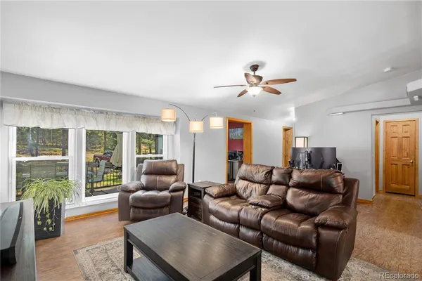 a living room with furniture and a large window with garden view