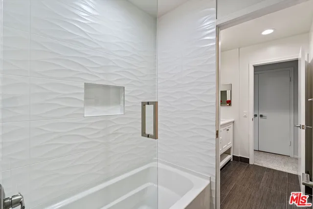 an empty room with wooden floor and natural light