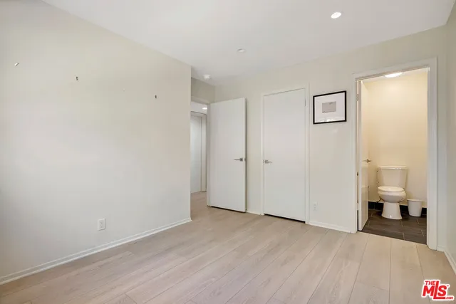 an empty room with wooden floor and window